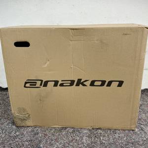 Der Versandkarton des Anakon Tender ist aufrecht abgebildet. Der Markenname „Anakon“ ist schwarz aufgedruckt.