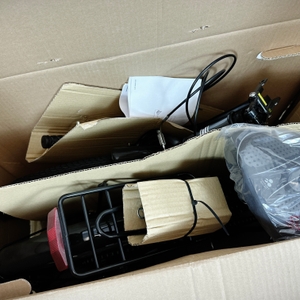 Im geöffneten Karton liegt das teilweise vormontierte Anakon Tender mit Zubehörteilen. Der Sattel ist separat verpackt.