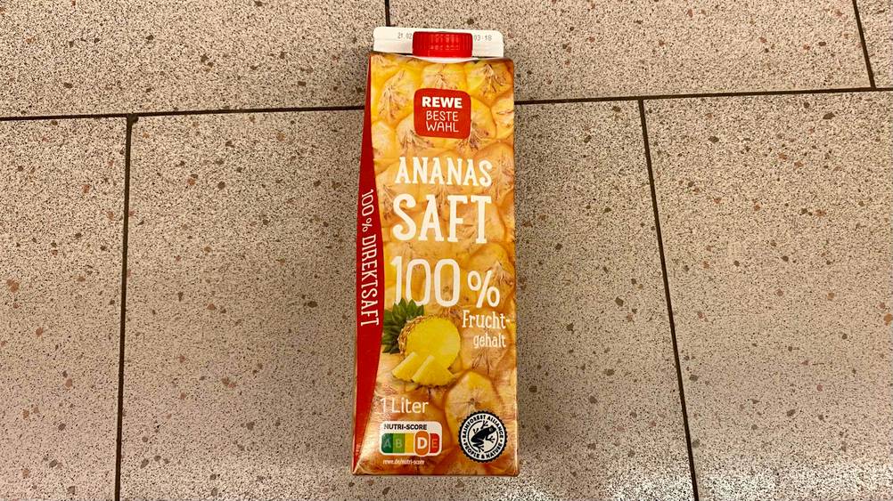 Ananassaft-Test: Päckchen mit Ananassaft liegt auf hllem Hintergrund
