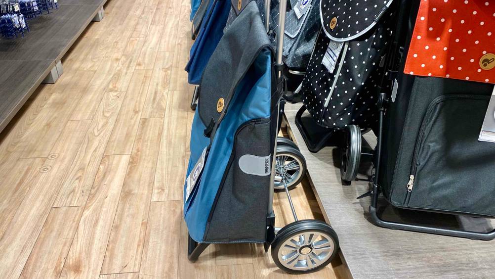 Ein getesteter Einkaufstrolley von der Seite neben anderen Trolleys in einer Verkaufsfläche stehend.