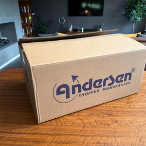 Der Karton des Andersen Scala Shopper Hera steht auf einem Tisch.