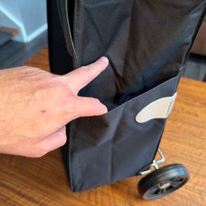 Eine Hand öffnet ein Fach an der Außenseite des Andersen Scala Shopper Hera.