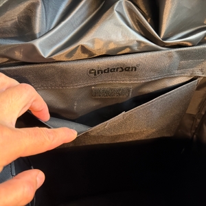 Eine Hand öffnet ein kleines Fach im Andersen Scala Shopper Hera.