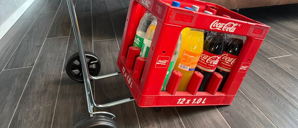 Ein Kasten mit Getränken steht halb auf dem Andersen Scala Shopper Hera.