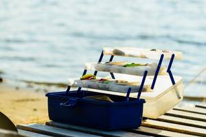 aufgeklappter angelkoffer am meer