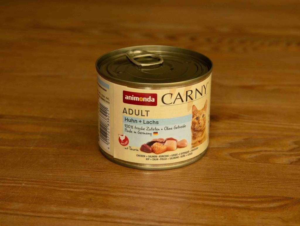 Ein getestetes, getreidefreies Nassfutter für Katzen steht in einer 200-g-Dose auf einer Holzfläche.