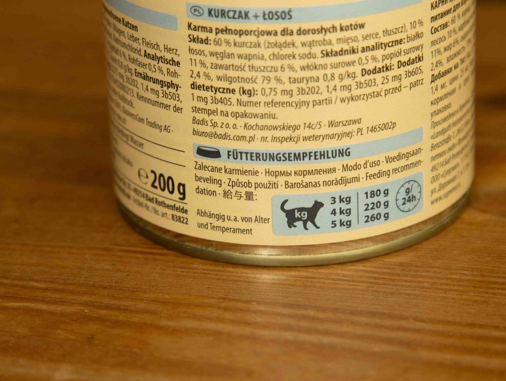 Ein getreidefreies Nassfutter für Katzen im Test steht in einer geöffneten 200-g-Dose auf einer Holzfläche.