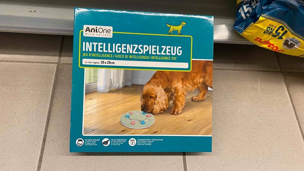 Im Test: Eine Packunge Hunde-Intelligenzspielzeug von AniOne steht auf Fliesenboden und lehnt an Regal.