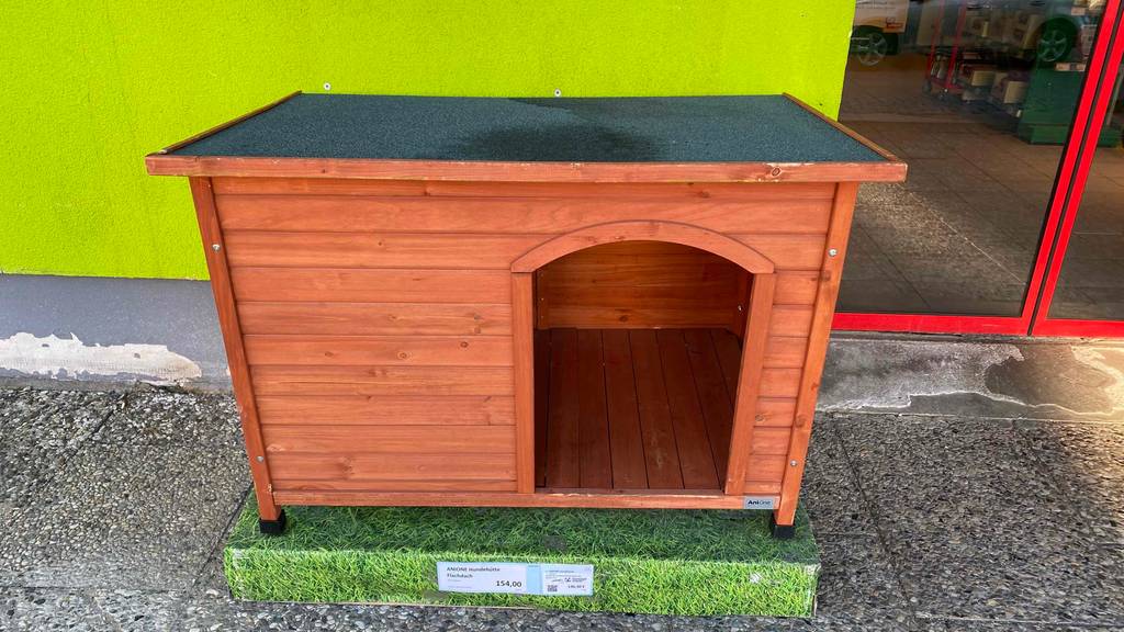 Im Test: Anione Holz Hundehütte steht auf einem Verkaufspodest.