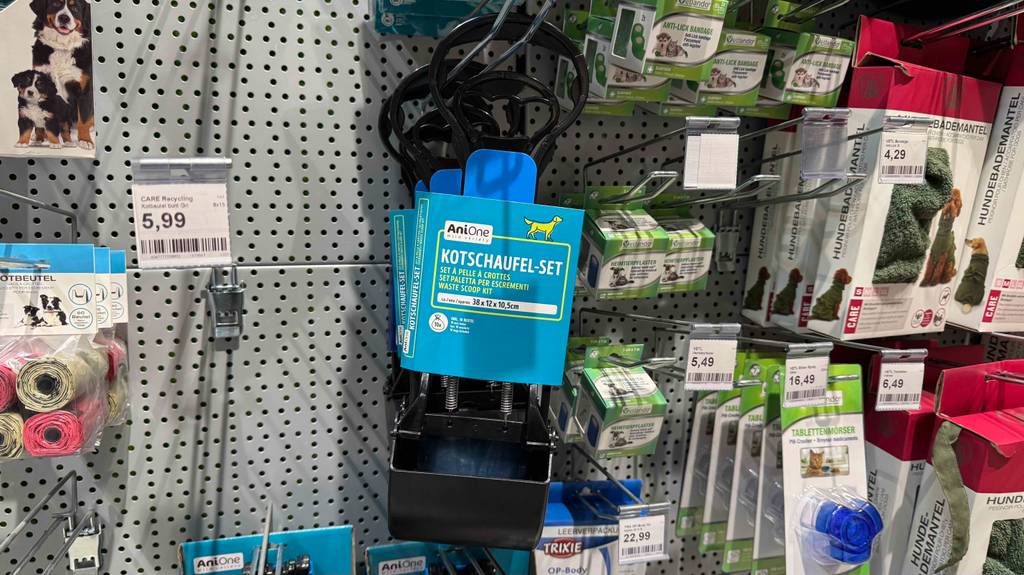 Im Test: Mehrere Hundekotschaufeln hängen zwischen anderen Produkten in einem Hängeregal.
