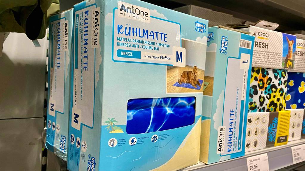 Getestete Kühlmatten für Hunde: Eine Verpackung mit Sichtfenster inklusive Kühlmatte in Größe M der Marke Anione steht in einem Verkaufsregal mit ähnlichen Produkten.