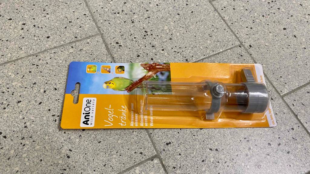 Getestete Vogeltränke von Anione liegt in der Original-Verpackung auf hellgrauen Fliesen.