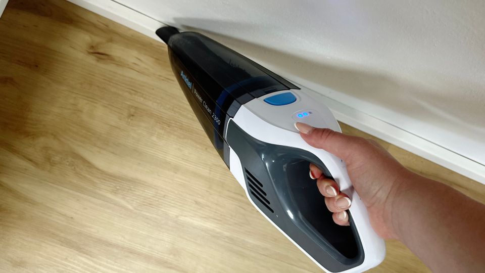 Hand zeigt den Anktel 601-N mit eingesetzter Fugendüse, der entlang einer Fußleiste saugt.
