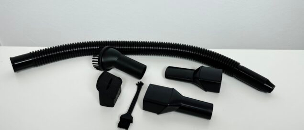 Zubehör-Set des Anktel 601-N bestehend aus Bürstenaufsatz, Verlängerungsschlauch, Fugendüsen und kleiner Reinigungsbürste auf weißem Untergrund.