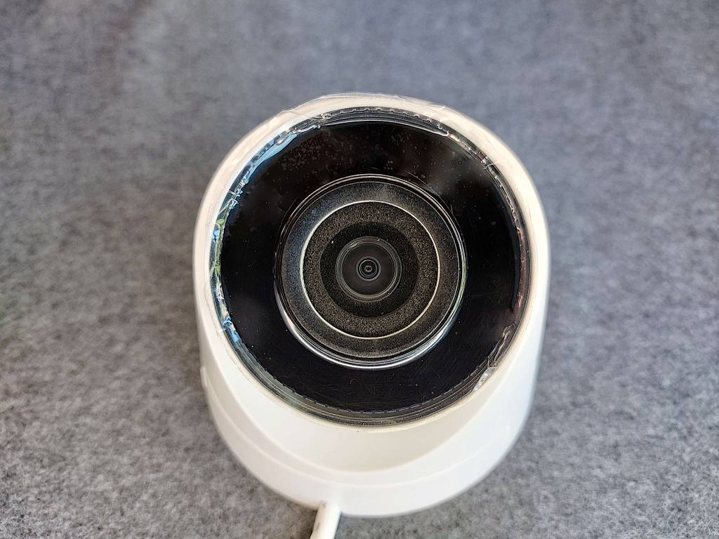 Frontaler Close-up einer weißen Überwachungskamera im Test. 