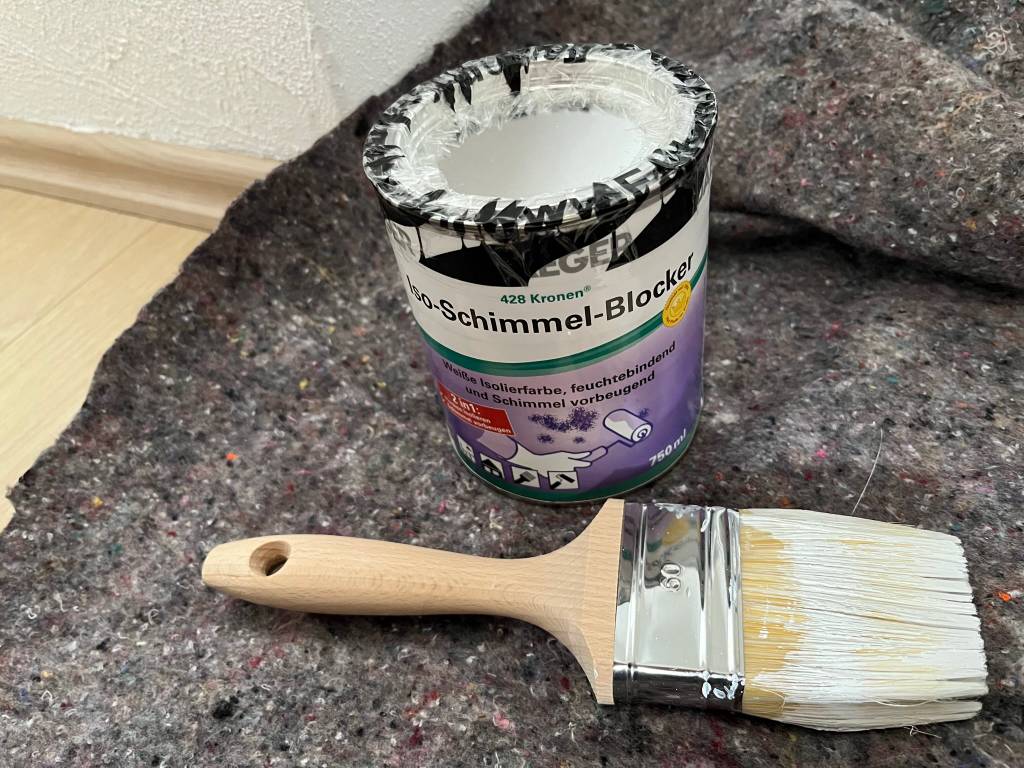 Zum sauberen Arbeiten mit Anti-Schimmel-Farbe dienen ein angemessener Pinsel sowie Malervlies.