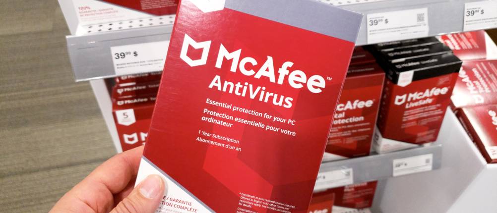 Antivirus-Apps getestet: Eine Person hält eine Produktverpackung von McAfee Antivirus in der Hand.