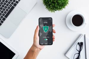 Antivirus-Apps im Test: Eine Frau hält ein Smartphone in der Hand, welches sich über eine App mit einem VPN verbindet.
