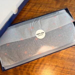 Die Aosun-Seiden-Schlafmaske liegt in ihrer Verpackung.