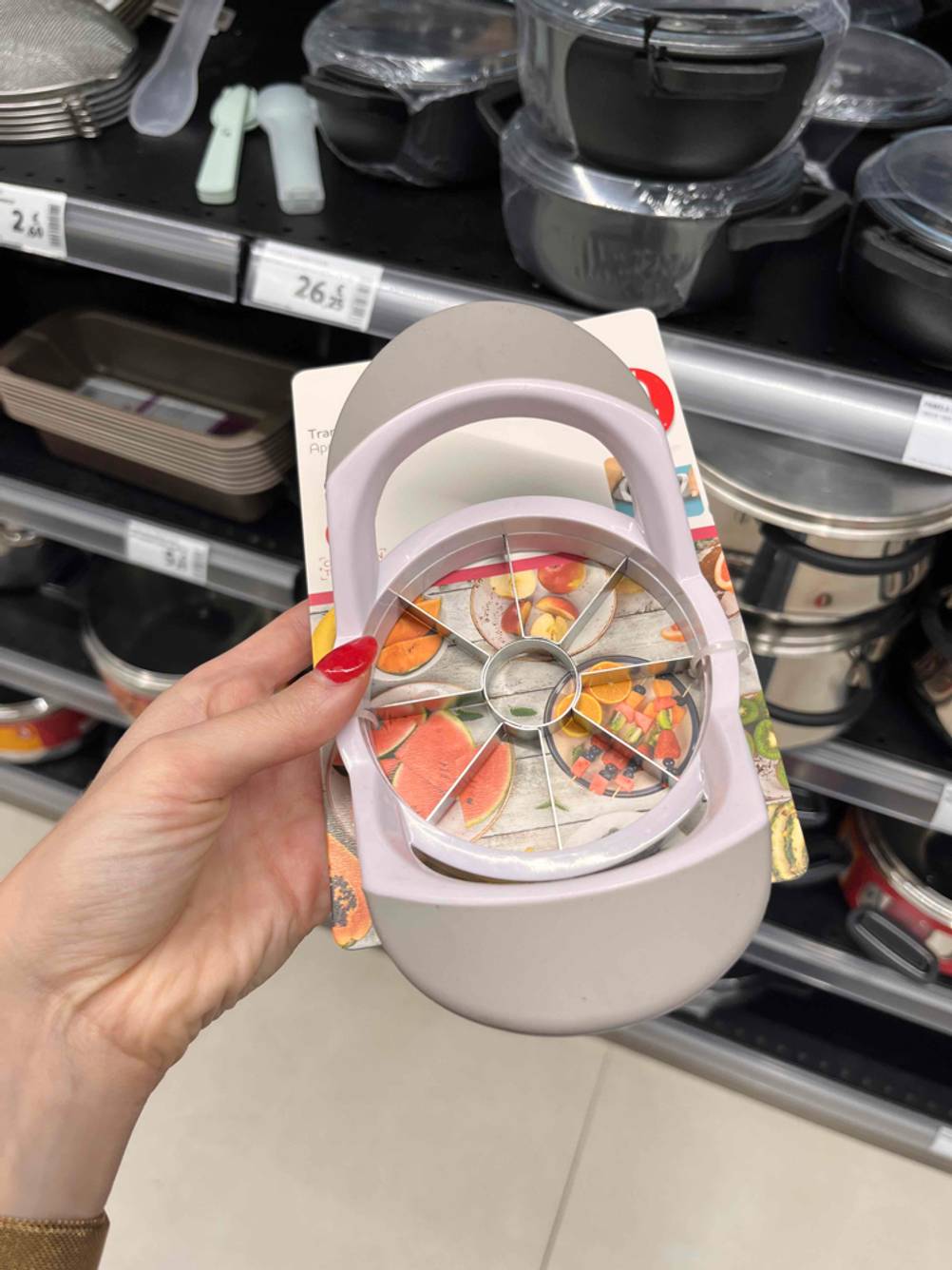 Eine Hand hält den verpackten Apfelschneider im Test leicht schräg.