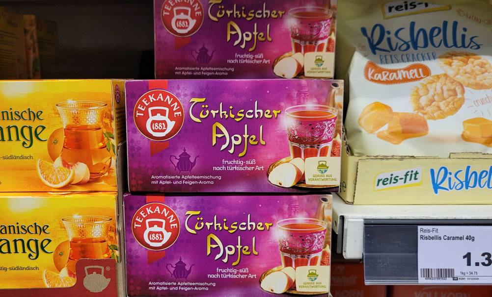 Mehrere Packungen des getesteten Apfeltees stehen in einem Regal übereinander.