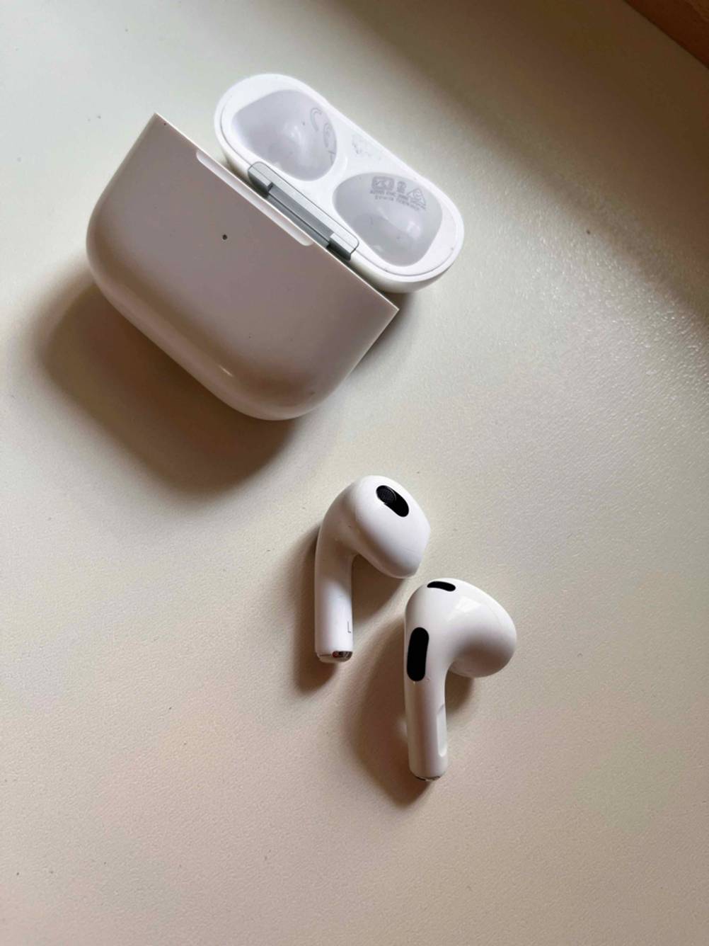 In-Ear-Headset-Test: ein weißes In-Ear-Headset liegt geöffnet auf einer hellen Oberfläche.