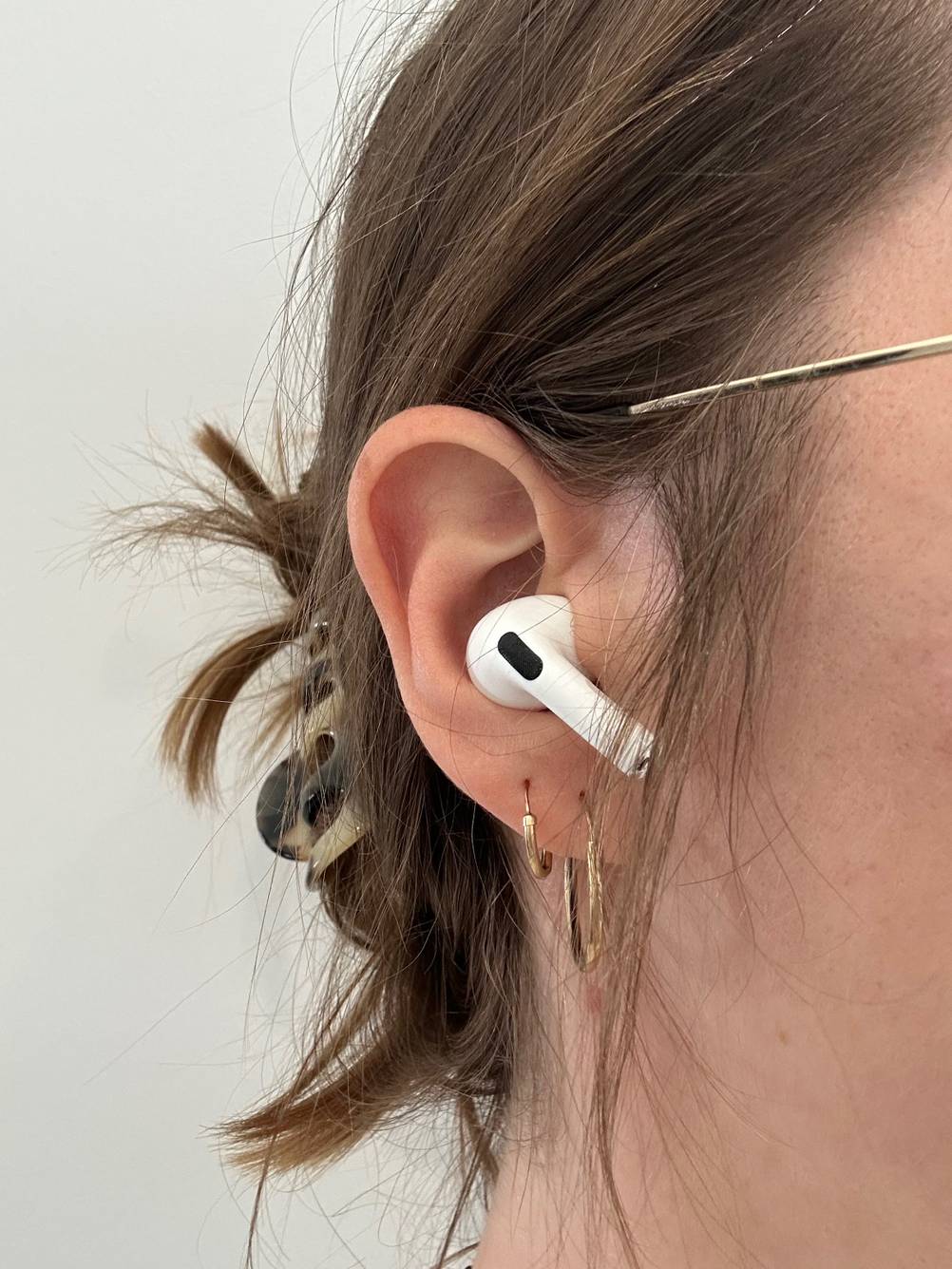 Ein weiblicher Kopf hat einen Wireless In-Ear-Kopfhörer im Ohr.