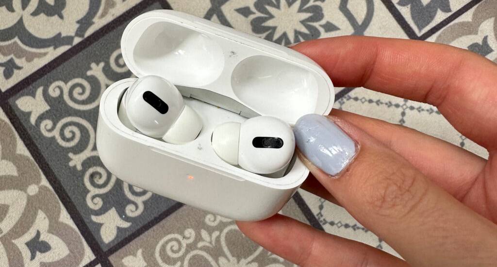 Im Test: True-Wireless-In-Ear-Kopfhörer in Weiß von einer Damenhand gehalten, im Hintergrund ein gemusterter Fliesenbelag.