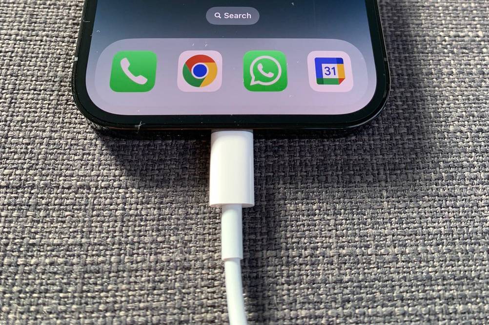 Das getestete Apple-iPhone hängt am Ladekabel.