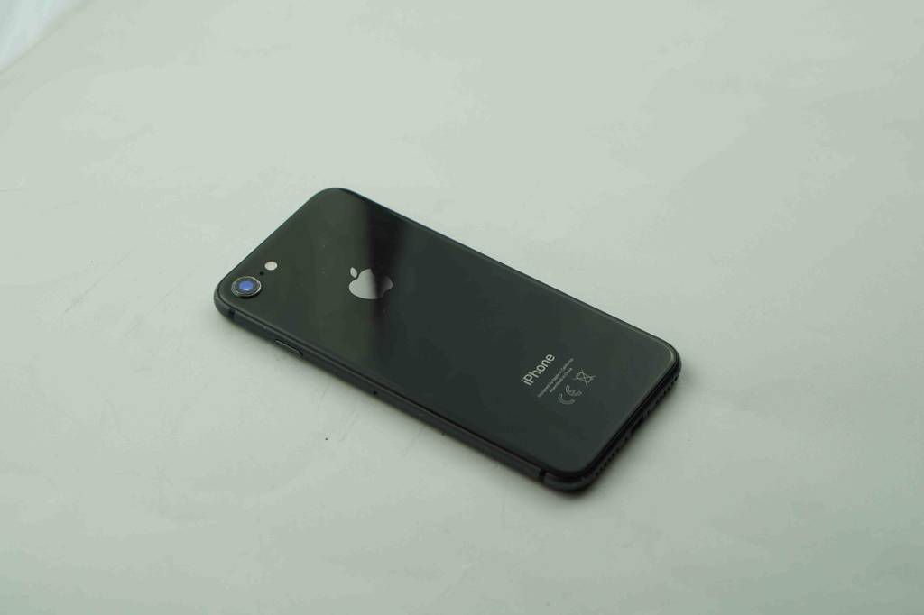 Smartphone-Test: schwarzes iPhone von Apple liegt mit sichtbarer Rückseite auf heller Oberfläche.