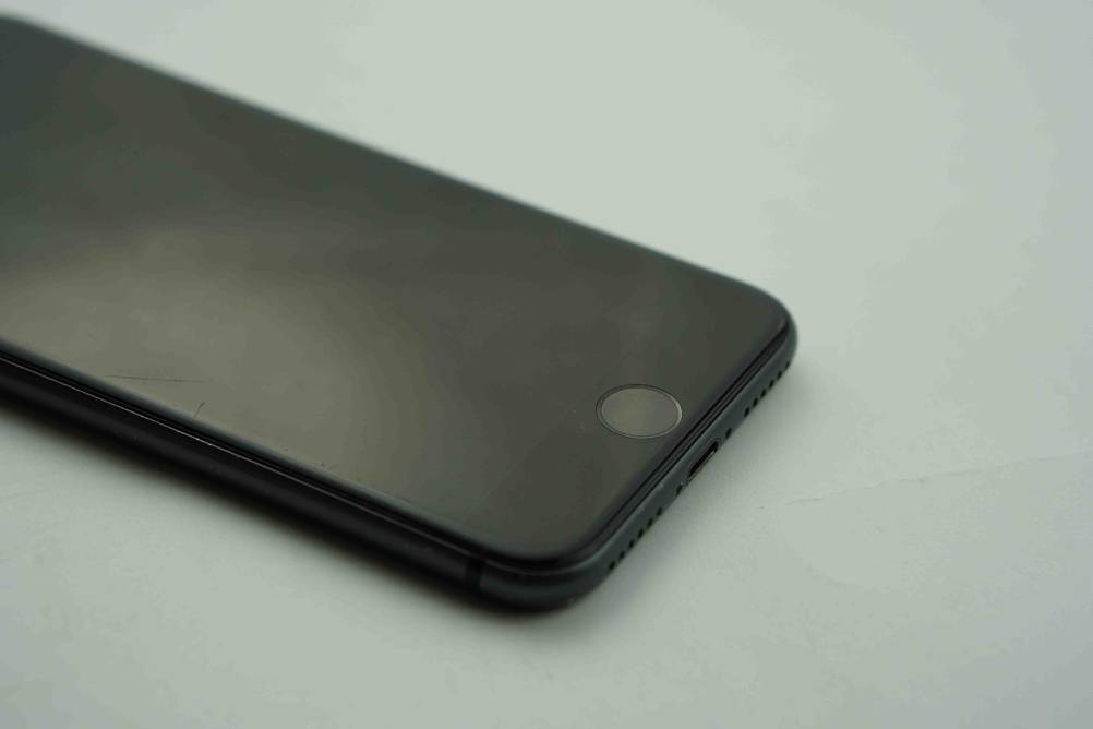 Smartphone im Test: Detailaufnahme einer schwarzen Ausführung, mit Fokus auf den USB-Slot sowie die Fingerabdruck-Erkennung.