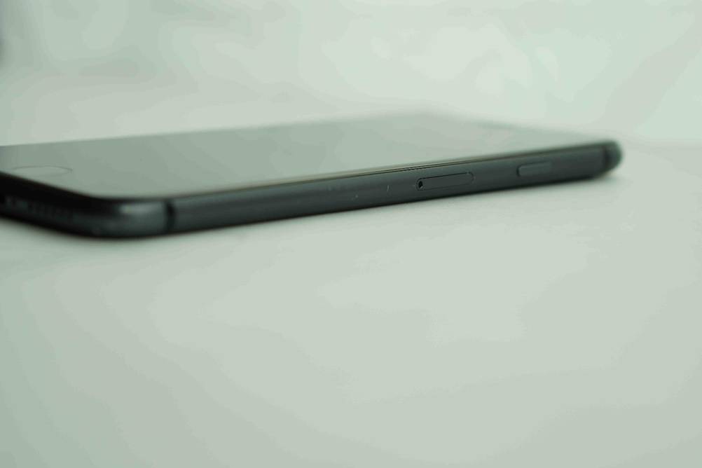 Smartphone-Test: ein schwarzes Modell, mit Fokus auf den Karten-Slot liegt auf einem hellen Untergrund.