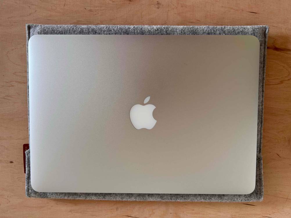 Apple MacBook getestet: Ein Gerät von oben auf einer grauen Hülle auf einem Holztische.