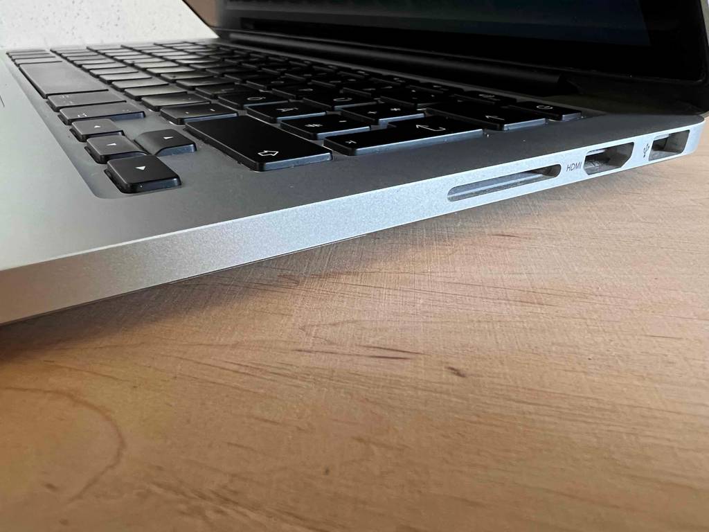 Nahaufnahme der Anschlüsse auf der rechten Seite eines leicht geöffneten Apple MacBooks im Test.