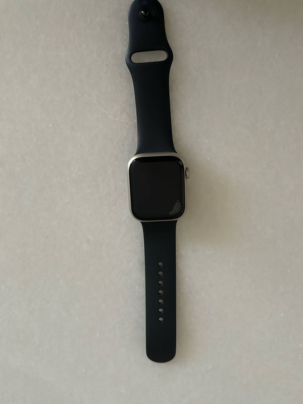 Im Test: Auf einer hellen Fläche liegt eine Smartwatch mit schwarzem Band.