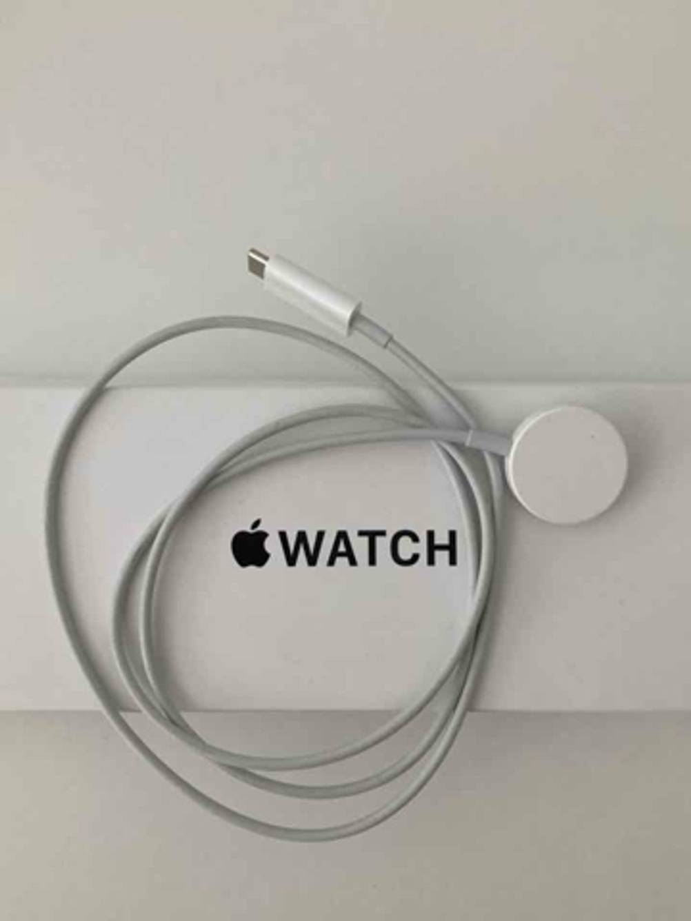 Das Apple-Watch-Ladekabel im Test liegt auf der Apple-Watch-Verpackung.
