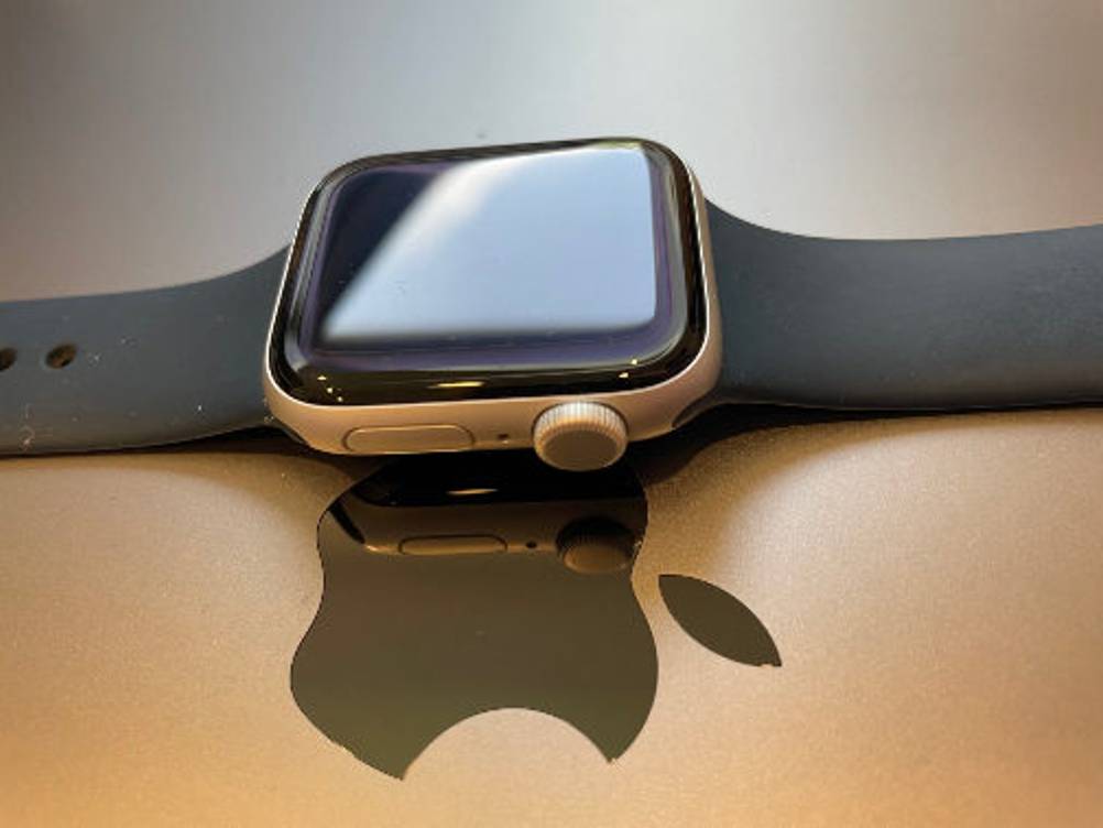 Apple Watch Test: Eine Uhr mit Band liegt auf einem glänzenden Apple Logo.