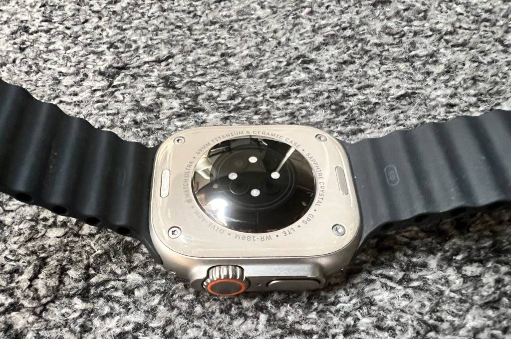 Rückseite einer Smartwatch-EKG im Test, die auf grauem Untergrund liegt.