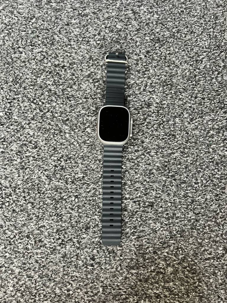 Eine ausgeschaltete getestete Smartwatch-EKG liegt auf einer grau-gesprenkelten Fläche.