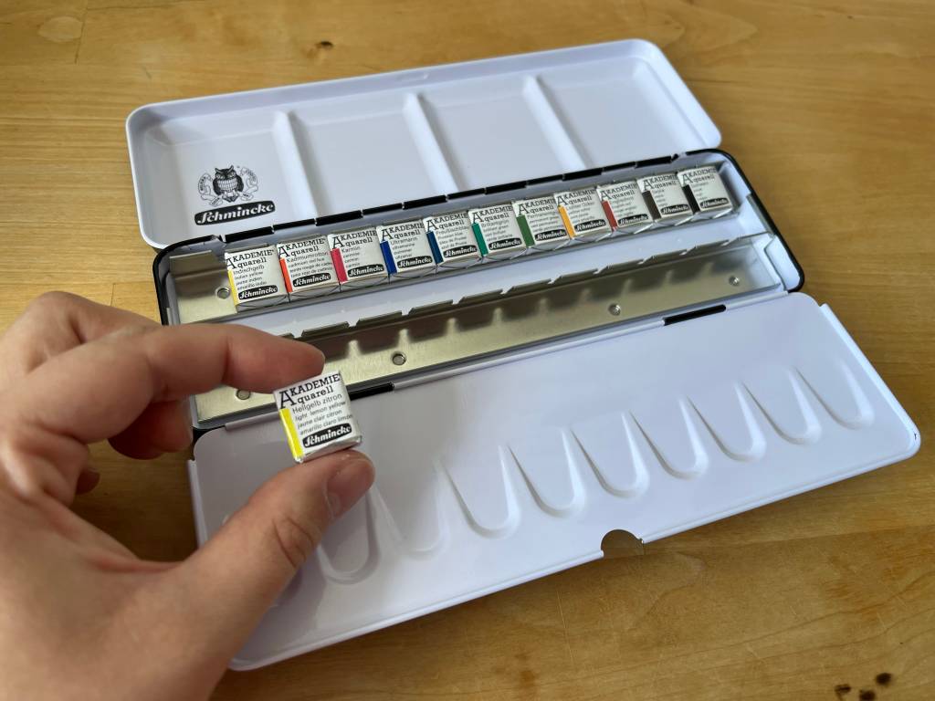 Auf dem Bild: ein Aquarellkasten der Marke Schminke inklusive unterschiedlicher und austauschbarer Farbe-Näpfchen.