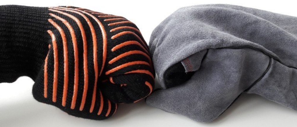 Ein Grillhandschuh aus Leder und Aramid liegen einander gegenüber.