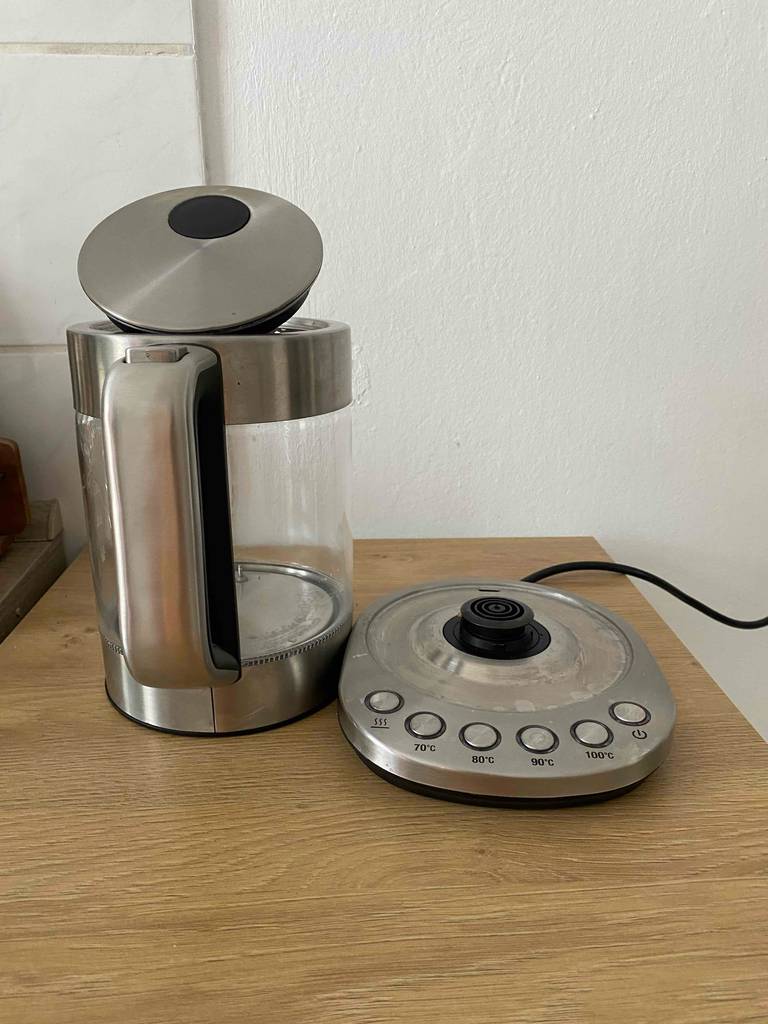 Wasserkocher 1,5 Liter im Test: Ein Modell der Marke Arendo aus Glas und Edelstahl steht neben seiner Basis mit mehreren Heizstufen-Tasten.