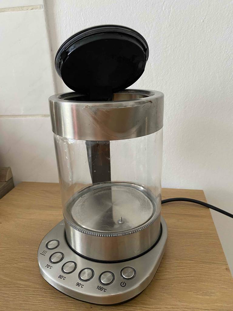 Der 1,5-Liter-Wasserkocher im Test steht mit geöffnetem Deckel auf seiner Basis, auf der sich mehrere Heizstufen-Tasten befinden.