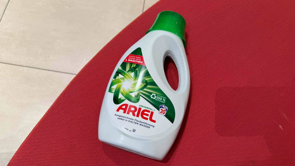 Eine Flasche des getesteten Ariel-Waschmittels von oben auf einem roten Polster.