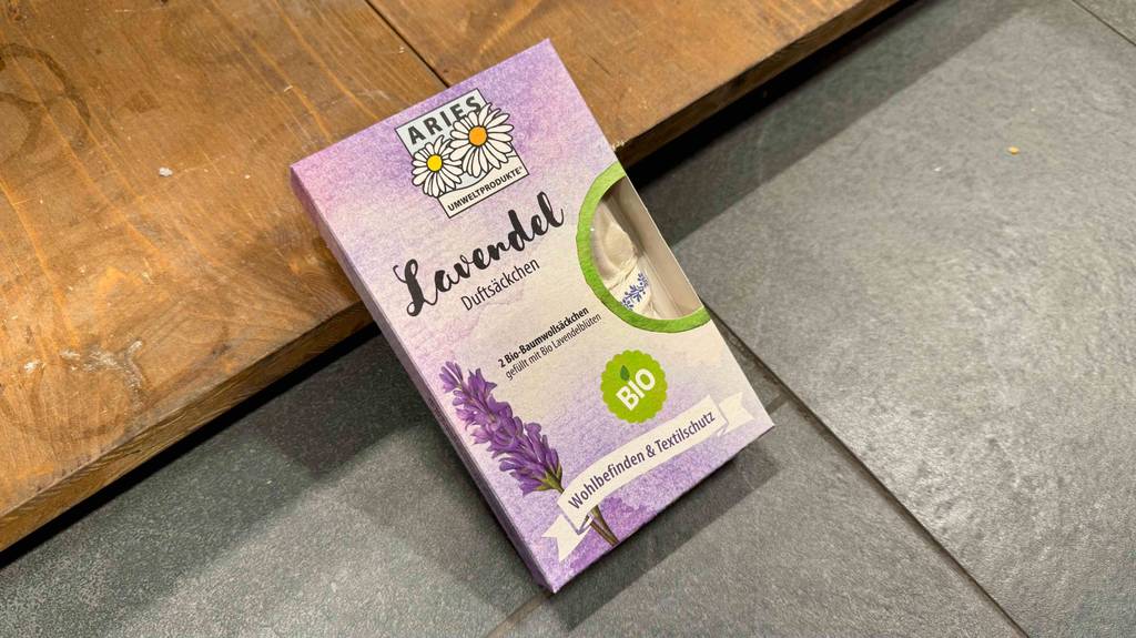 Eine Packung Lavendelsäckchen liegt zum testen halb auf einem Holzbrett.