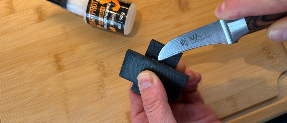 Mit einem Messer wird ein mit dem Arka-Sekundenkleber-extra-stark-Gel verklebtes Stück Plastik angeschnitten