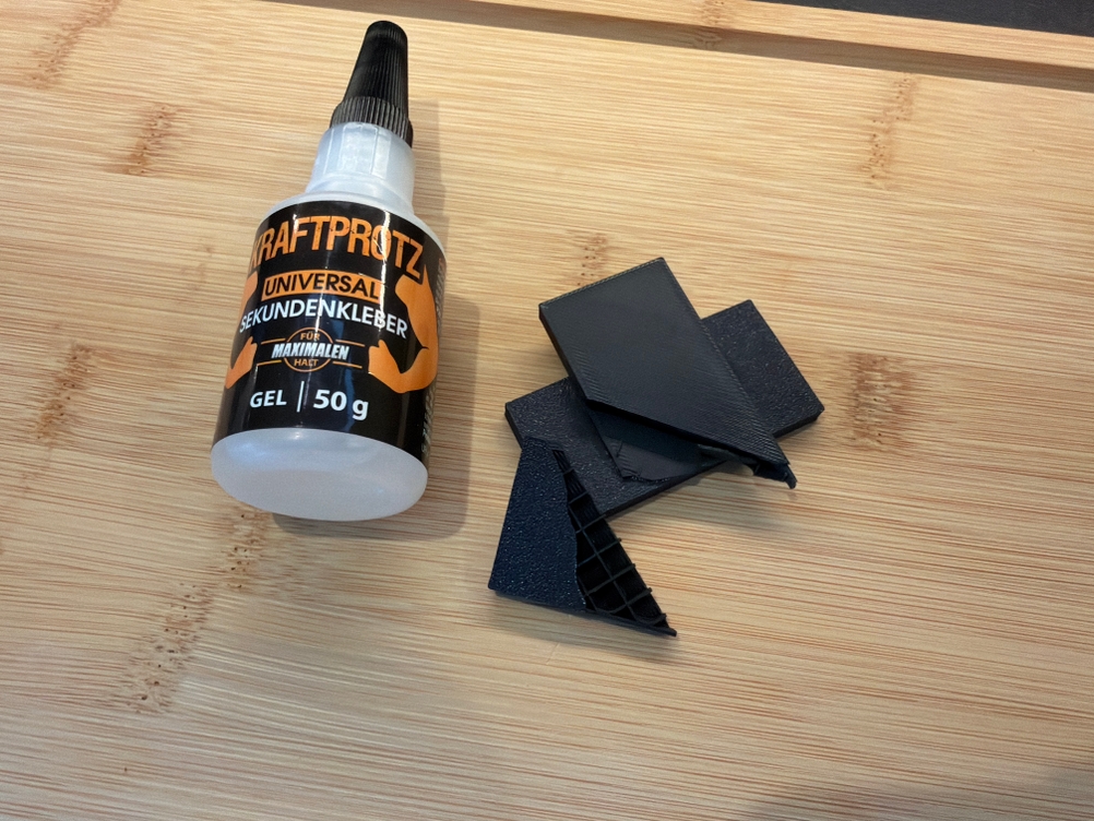 Ein gebrochenes Stück Plastik liegt neben dem Arka-Sekundenkleber-extra-stark-Gel