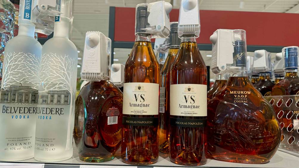 Armagnac getestet: Mehrere Flaschen neben anderen Produkten in einem Verkaufsregal.
