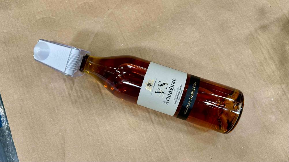 Eine Flasche des getesteten Armagnac auf einem Karton liegend.