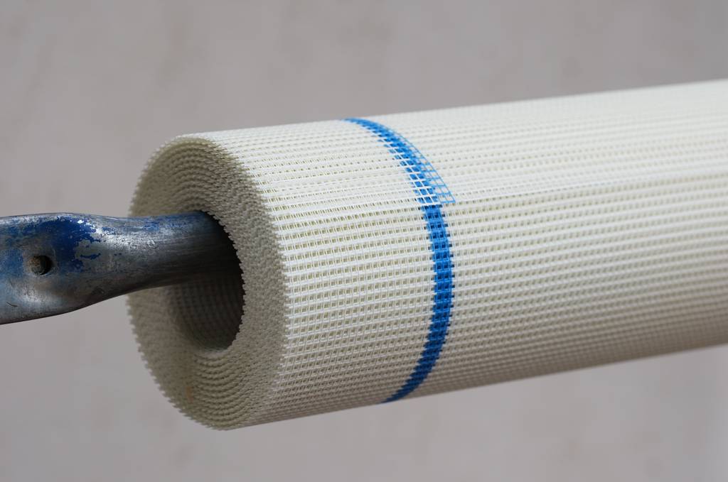 Armierungsgewebe im Test: Eine Rolle Armierungsgewebe mit blauem Streifen hängt an einer Metallstange.
